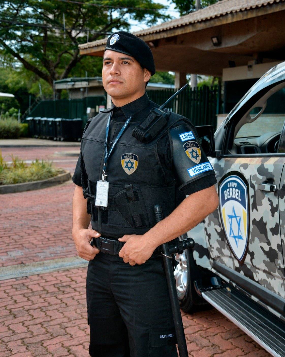 Vigilante do Grupo Berbel ao lado de viatura identificada